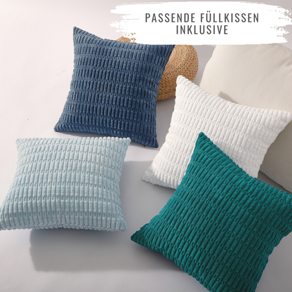 Vier große Kissen in verschiedenen Farben auf einem hellen Hintergrund von Interior by Hakito – 4er Set Kissen Mosa Kordsamt für Sofa, Stuhl & Bett.