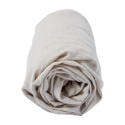 Gerolltes beiges Reine Leinen Spannbettlaken GOTS von Hakito – ideal für Allergiker und umweltfreundlich.