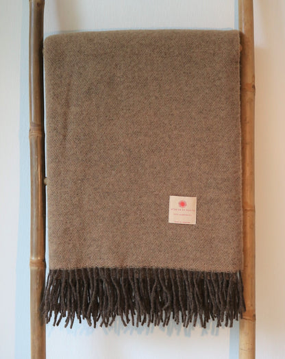 Warme Merino Wolle Tagesdecke von Interior by Hakito in einem eleganten Braunton mit ausgefallenen Fransen, eine stilvolle Ergänzung für Ihr Zuhause.
