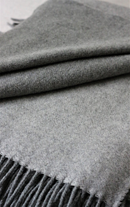 Gefaltete graue Merino Wolle Tagesdecke 140x200 cm von Interior by Hakito, die weiche und gemütliche Materialstruktur betont.