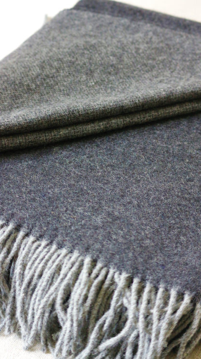 Warme Merino Wolle Tagesdecke von Interior by Hakito, grau mit fransen, eine weiche und atmungsaktive Textur.