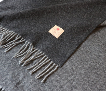 Warme Merino Wolle Tagesdecke von Interior by Hakito, dunkelgrau mit fransen, perfekt für kuschelige Abende.