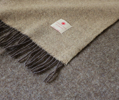 Nahaufnahme der Robusten Lammwolle Tagesdecke von Interior by Hakito, zeigt die kuschelige Textur und die stilvollen Fransen, ideal für gemütliche Abende.