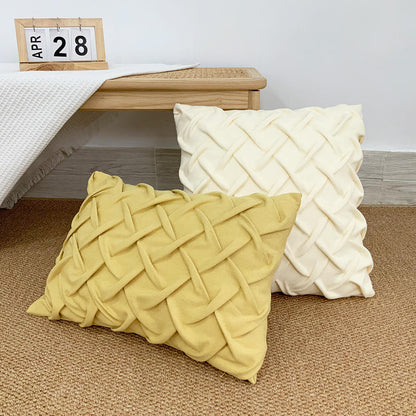 Zwei stilvolle Kissen Knot von Interior by Hakito mit luxuriösem Knoten-Look in Beige und Gelb auf einem Teppich. Perfekt für ein modernes Zuhause.