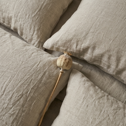 Nahaufnahme von Reine Leinen Bettwäsche GOTS von Hakito. Die strukturierten Kissen und eine dekorative Blume bringen natürliche Eleganz ins Schlafzimmer.
