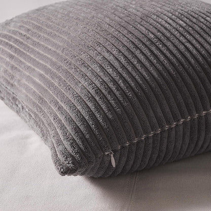 Detailaufnahme eines grauen Oeko-Tex Kissens von Interior by Hakito, präsentiert die weiche Struktur und Qualität der Polyesterfüllung.