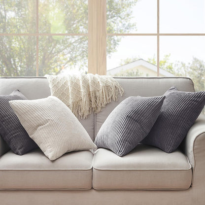 Helles Wohnzimmer mit einem 4er Set Oeko-Tex Kissen von Interior by Hakito, stilvolle Mischung aus Kissen auf einem gemütlichen Sofa.