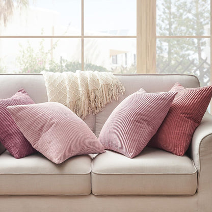 Gemütliche Couch mit mehreren Kissen in Rosa und lila aus dem 4er Set Oeko-Tex Kissen von Mary Kordsamt – tolle Ergänzung für Ihr Zuhause von Interior by Hakito.