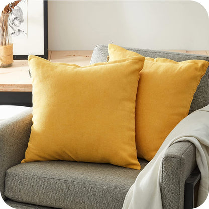 Kissen Nino 2er Set von Interior by Hakito, gelbe Kissen auf einer gemütlichen Couch, perfekt für Innen- und Außenbereich.