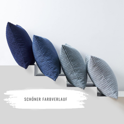 Schöner Farbverlauf der Kissen im Modell Sven Kordsamt von Interior by Hakito, elegant präsentiert auf einer minimalistischen Oberfläche.