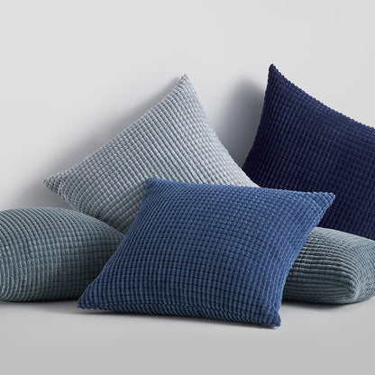 Vier gepolsterte Kissen in verschiedenen Farben, Teil des 4er Sets von Interior by Hakito - Modell Sven Kordsamt, perfekt für Stil und Komfort auf Sofa und Stuhl.