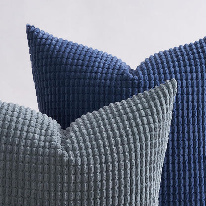 Nahaufnahme von zwei Kissen in Blau und Grau aus dem 4er Set von Interior by Hakito - Modell Sven Kordsamt, für optimale Unterstützung und elegantes Design.