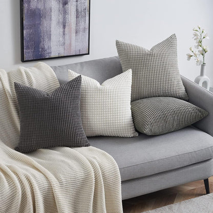 Elegante Kissenarrangements auf einem grauen Sofa, Teil des 4er Sets von Interior by Hakito - Modell Sven Kordsamt, perfekter Komfort für Ihr Wohnzimmer.