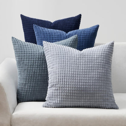 4er Set bequeme Kissen im Modell Sven Kordsamt von Interior by Hakito, in sanften Blau- und Grautönen auf einer hellen Couch.